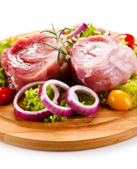 Raw meat on cutting board and vegetables 