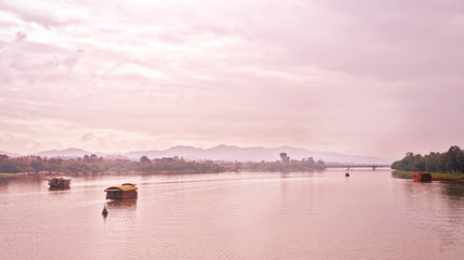 Fototapeta premium Hue, Vietnam - November 22, 2014: boats on the river lonely run to turn ripples, the mountains and the clouds away is to make real peace scenery of the countryside in Hue, Vietnam