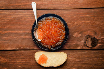 blue plate. wood planks. Sandwich with butter and caviar
