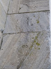 Zeichen auf der Fassade der San Nicolas Kirche in Portomarin