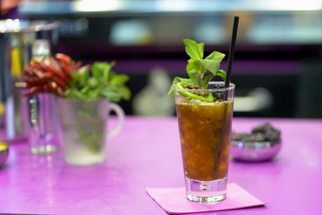 cocktails freshly on the rock prepared with natural ingredients on purple table