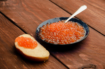 blue plate. wood planks. Sandwich with butter and caviar