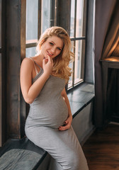 Fototapeta premium girl waiting for child. She is sitting on window and smiling