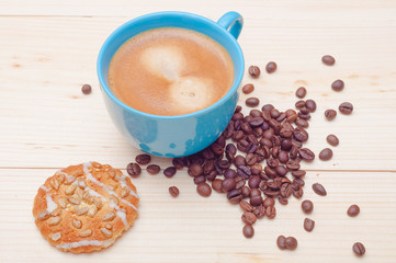 Cup of coffee, cookie with sunflower seeds and coffee beans. Swe