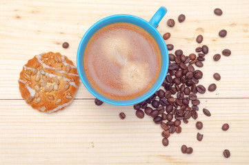 Cup of coffee, cookie with sunflower seeds and coffee beans, top