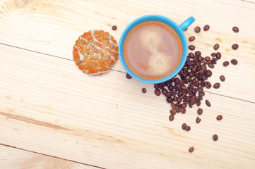 Cup of coffee, cookie with sunflower seeds and coffee beans, top