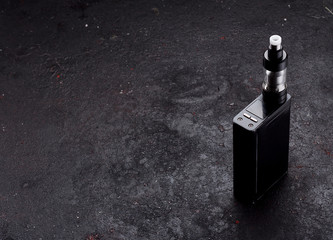 An electonic cigarette over dark concrete background