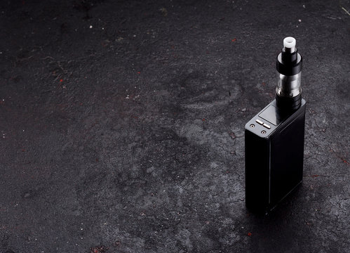 An electonic cigarette over dark concrete background