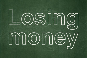 Money concept: Losing Money on chalkboard background