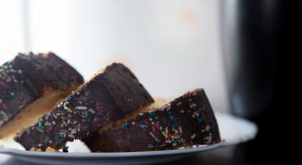 Horizontal image of three slices of homemade chocolate cake with black cup on background shot with daylight