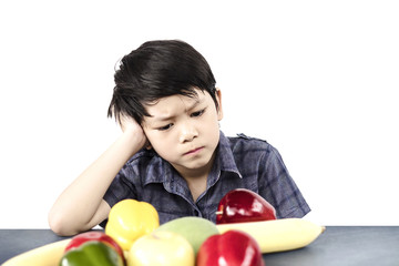 Fototapeta premium Asian boy is showing dislike vegetable expression over white background