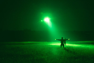 marshaller signal to helicopter for night landing from night vision goggles view