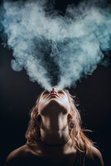 Fototapeta premium Portrait of girl blowing smoke