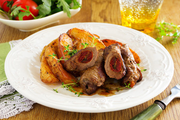Pork rolls with dried tomatoes and baked potatoes.
