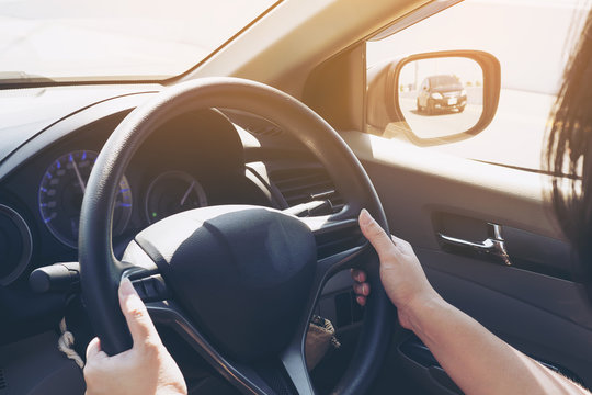 Woman driving car using two hand