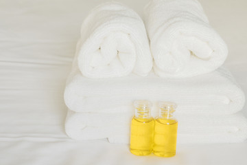 Fototapeta na wymiar Hotel towel with shampoo and soap bottle set on white bed