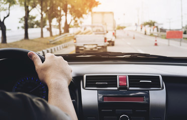 Close up of a man driving car using one hand, dangerous behavior