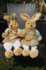 Fototapeta premium Osterhase aus Stroh sitzt auf einem Stuhl