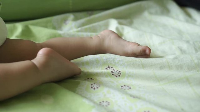 A year old Asian baby sleeping on the bed
