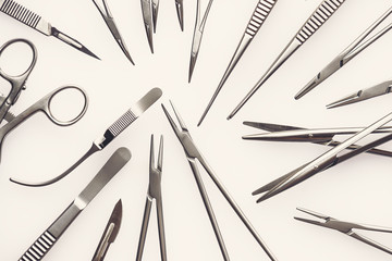 Flat view on assorted surgical instruments on a white background