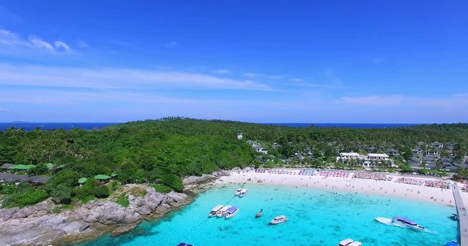 Racha Island Beach. Thailand, Phuket. Yachts , Catamarans and Boats sailing in crrystal clear blue water of ocean. Flying from ocean to sandy beach. Aerial view. 4K.