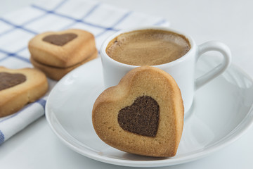 coffee concept/cup of coffee and cookies shaped heart on white background close up, selective focus