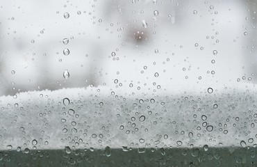 Snow and rain seen through a window during a snow storm