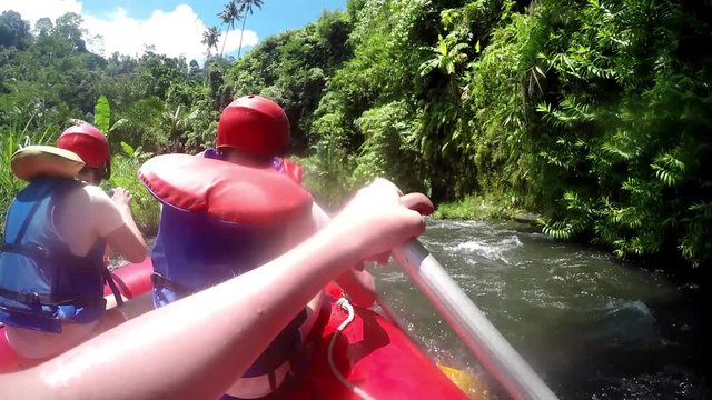 River Rafting. Team of four adult people white water rafting. Slow motion.