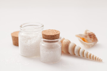 Fototapeta na wymiar seashell and jar of salt on white background