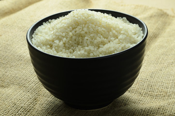 japanese rice in a black bowl on background