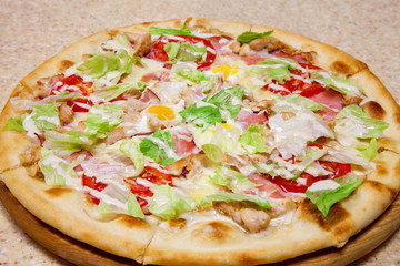 pizza on a round wooden plate.