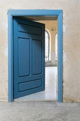 Blue wooden vintage door with yellow plaster wall