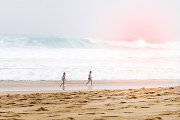 Fototapeta na wymiar Boy and girl of preschool age playing on the beach at sunset.