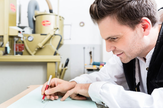 Handwerker fertigt Zeichenvorlage f&uuml;r Steininschrift an