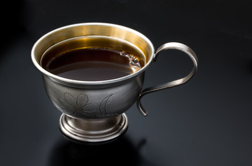 Vintage silverware, very old rich decorated metal cup of coffee