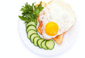 Fried egg on white toast with fresh cucumber and parsley.