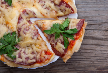 Delicious italian pizza on dark wooden background top view.