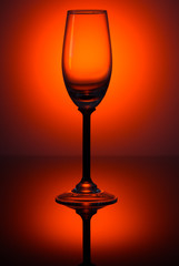 Empty wine glass on a rich dark red gradient background.