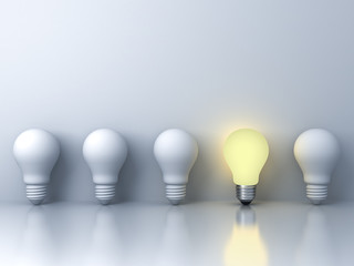 One glowing light bulb standing out from the unlit incandescent bulbs on white background with reflection The business concept and individuality concept 3D rendering