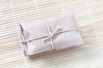 Wrapped parcel, paper package tied with rough cord or burlap rope. Delivery service wallpaper