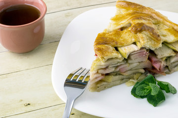 Traditional American apple pie and Cup of tea on light wood background