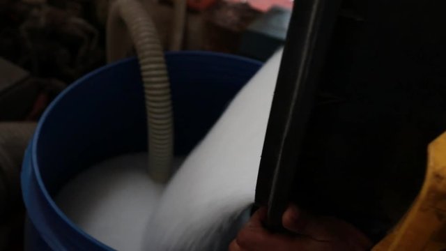 Pouring polyethylene plastic material into container