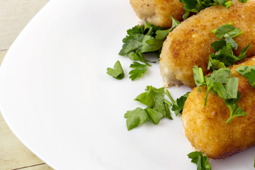 Chicken cordon bleu on light wood background