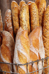 Fresh baguettes in metal basket in bakery