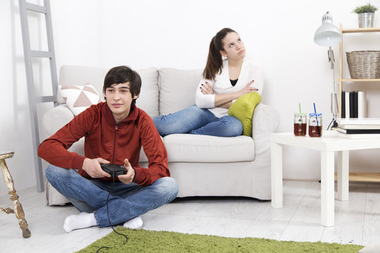 Girl is bored and angry while her boyfriend playing video game