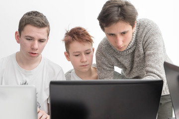 school boys working on a laptop. children are engaged with the computer. Boy working with laptop. students in the classroom. boys solve the problem in a laptop
