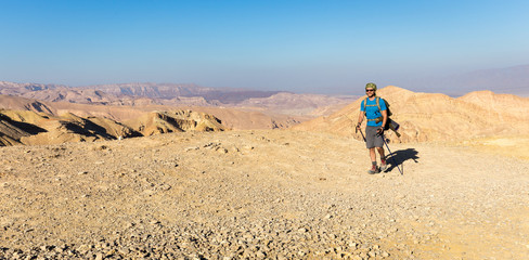 Backpacker tourist  walking desert stone mountain plateau.