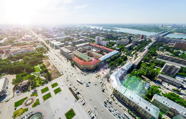 Aerial city view with crossroads and roads, houses, buildings, parks and parking lots, bridges. Copter shot. Panoramic image.