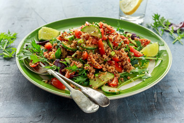 Quinoa tabbouleh salad with tomatoes, cucumber green onion. Concept healthy food