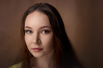 Close-up portrait of girl isolated on a brown background with professional makeup.